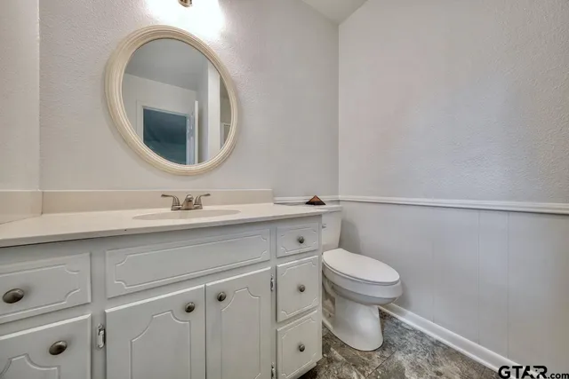 a bathroom with a sink a toilet and a mirror