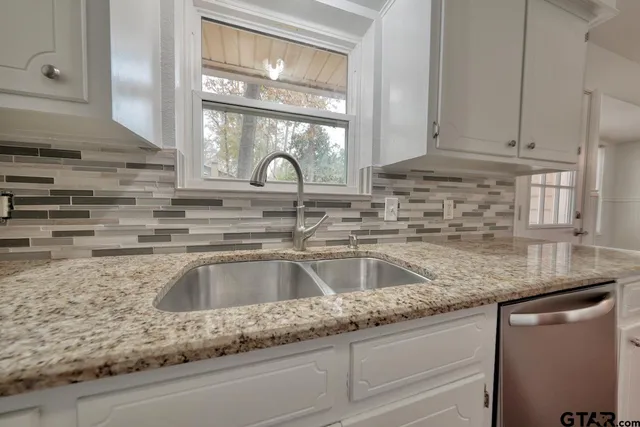 a kitchen with granite countertop a sink and a wooden cabinets