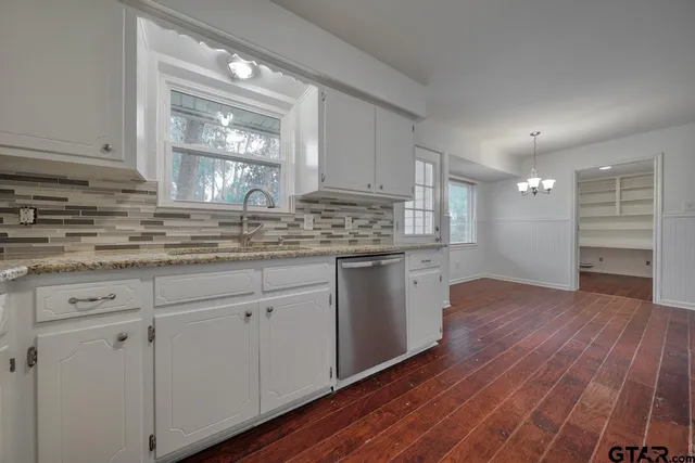 a kitchen with wooden floors and cabinets