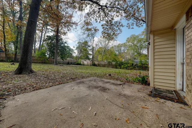a front view of a house with a garden and trees