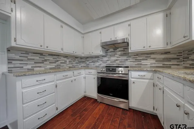a kitchen with granite countertop wooden cabinets and white appliances