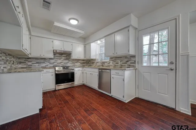 a kitchen with stainless steel appliances granite countertop wooden floors and sink
