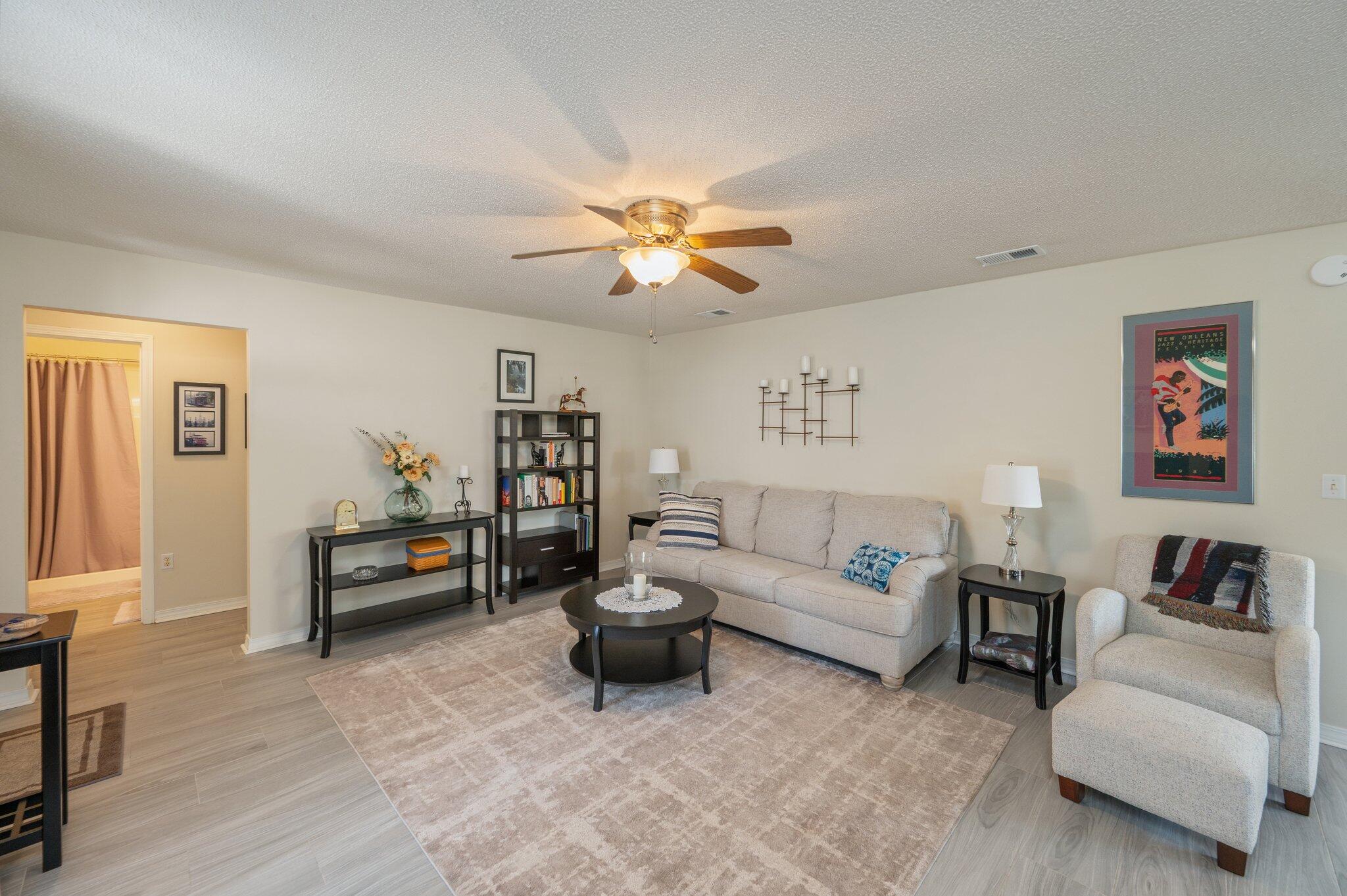 642 Alysheba Drive Crestview, FL 32539 - Photo 7 of 32 a living room with furniture and a chandelier