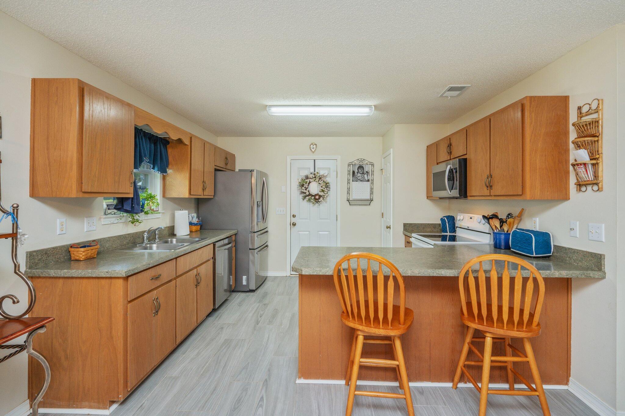 642 Alysheba Drive Crestview, FL 32539 - Photo 8 of 32 a kitchen with stainless steel appliances granite countertop a kitchen island hardwood floor sink stove and granite counter top