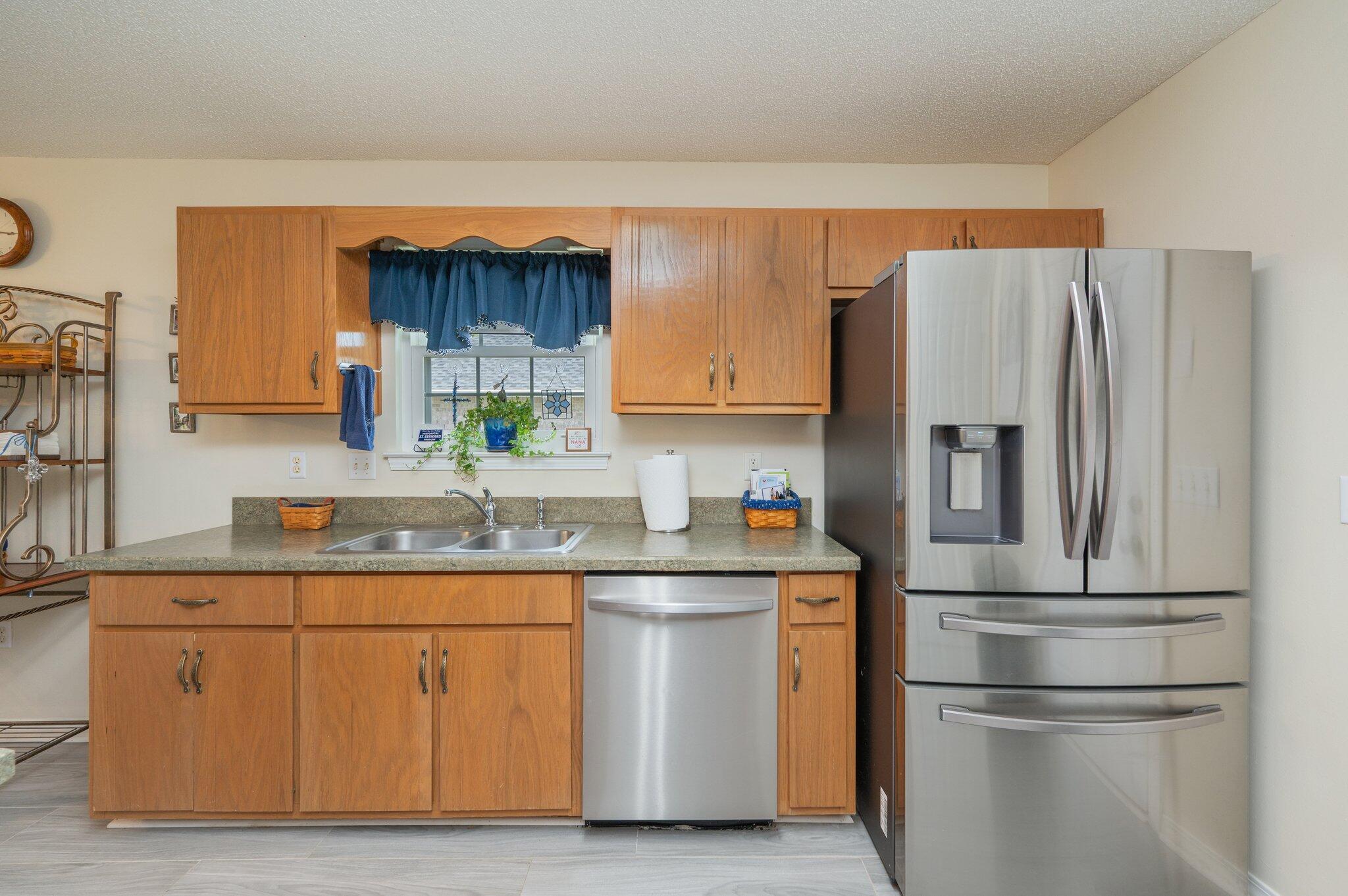 642 Alysheba Drive Crestview, FL 32539 - Photo 10 of 32 a kitchen with stainless steel appliances granite countertop a refrigerator a sink and white cabinets