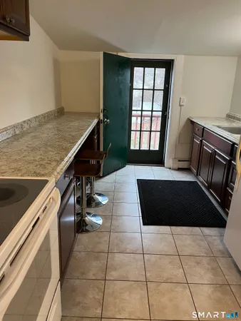 a kitchen with a sink a stove and a wooden floor