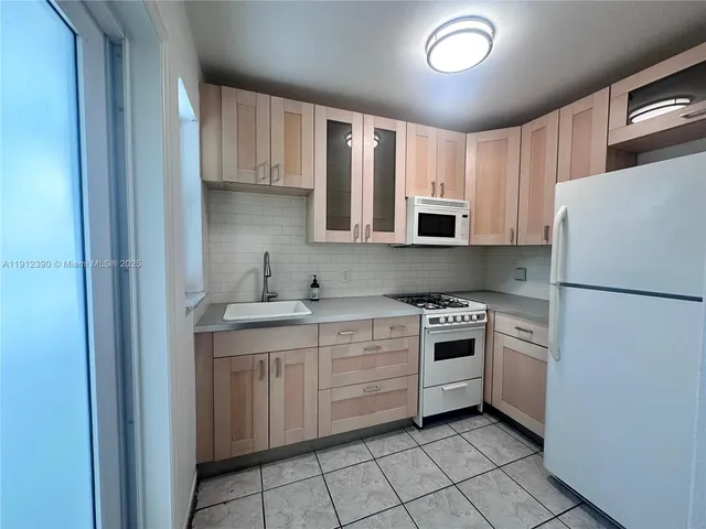 a kitchen with a stove sink and refrigerator