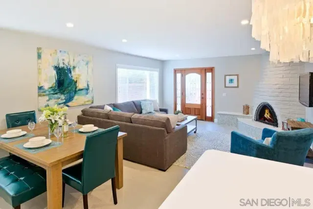 a living room with furniture potted plant a window and a kitchen view