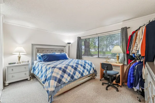 a bedroom with a large bed and a flat tv screen on a dresser
