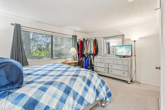 a bedroom with a bed and a flat tv screen in it