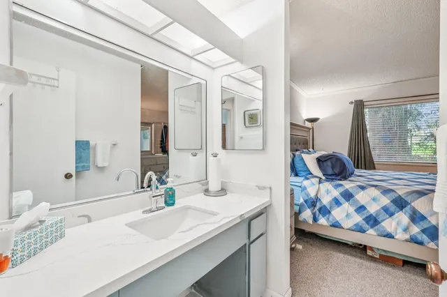 a bedroom with a bed and a large mirror on the dresser