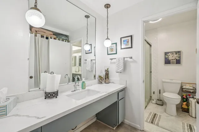 a bathroom with a double vanity sink mirror and toilet