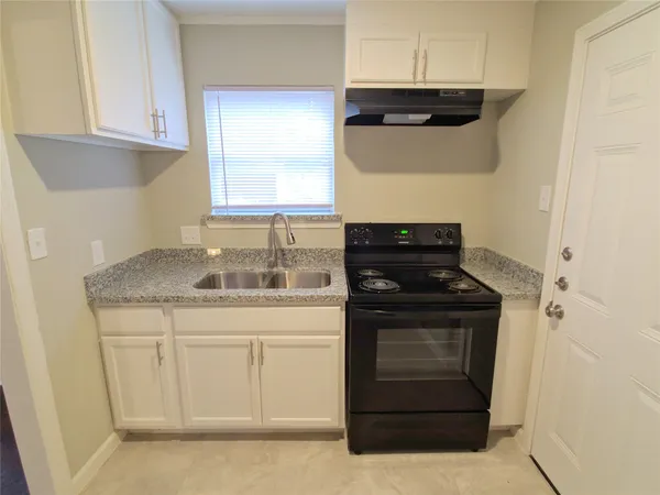 a kitchen with granite countertop white cabinets and stainless steel appliances