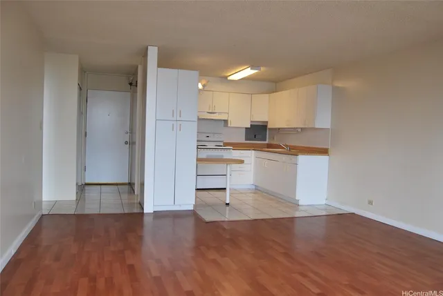 a kitchen with a refrigerator and white cabinets