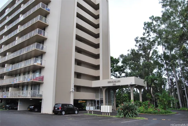 a front view of a building with streets and trees