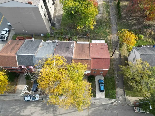 an aerial view of a house with garden space and street view