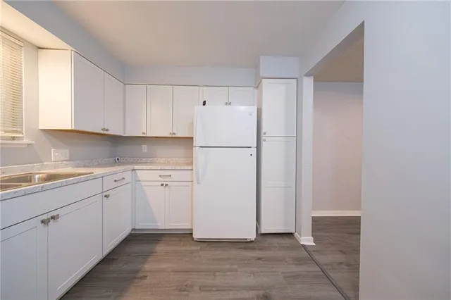 a kitchen with white cabinets and white appliances