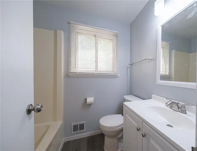 a bathroom with a sink toilet and window