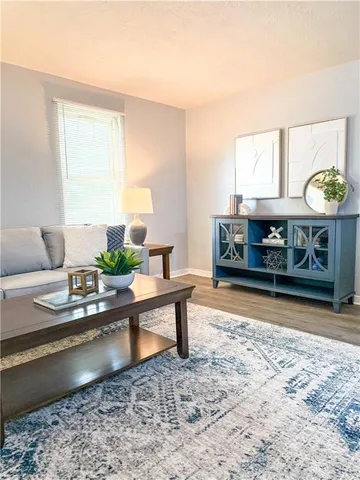 a living room with stainless steel appliances granite countertop furniture and a fireplace