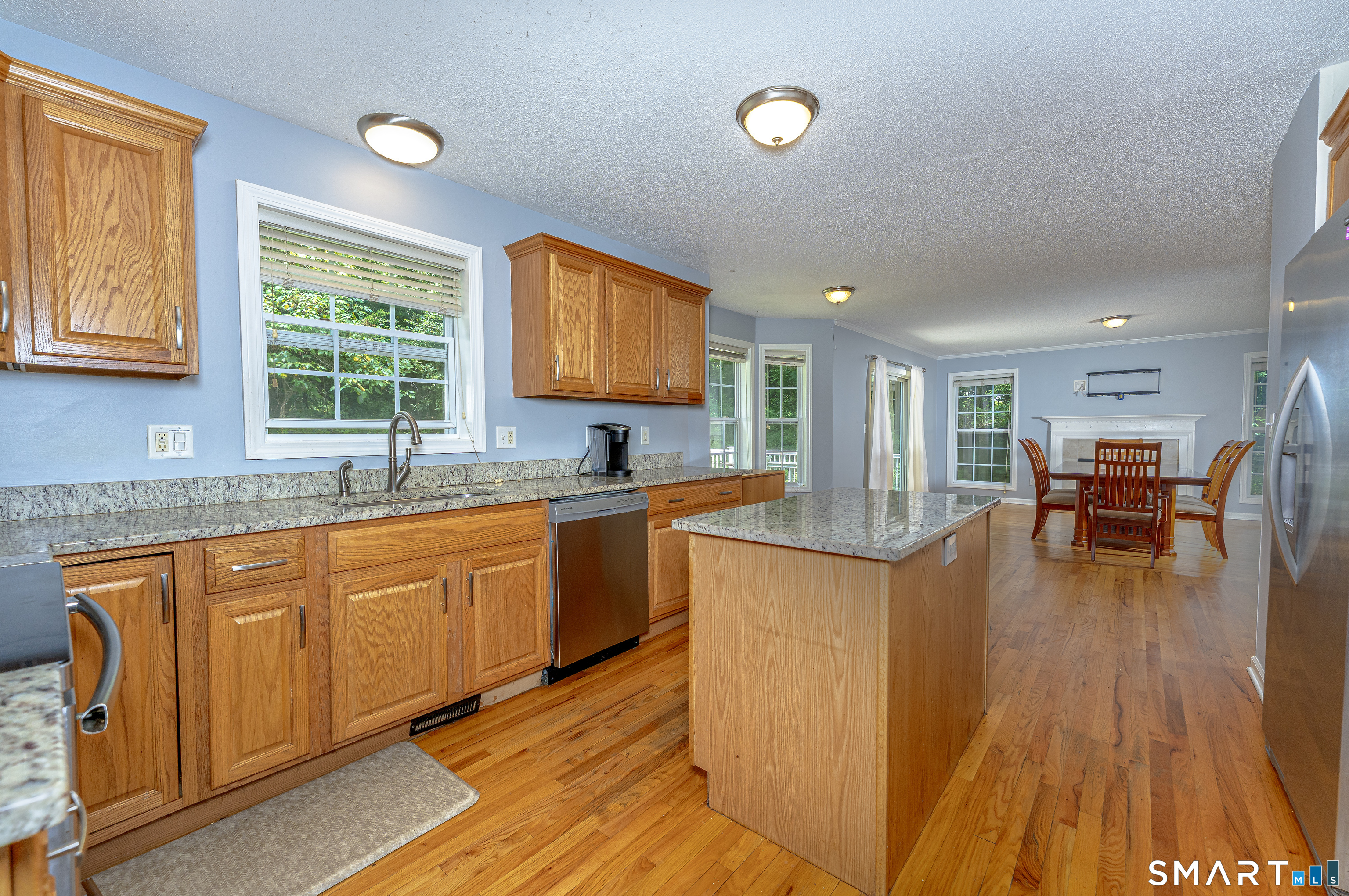 20 Gaylord Mountain Road Hamden, CT 06518 - Photo 20 of 37 a kitchen with stainless steel appliances granite countertop wooden floors a stove a sink and a window
