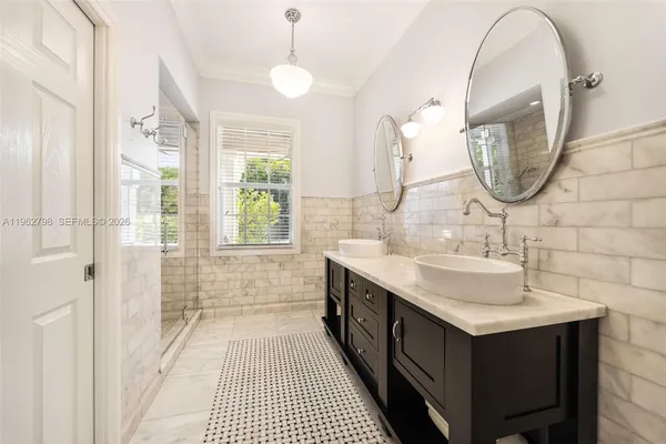a bathroom with a double vanity sink mirror and shower