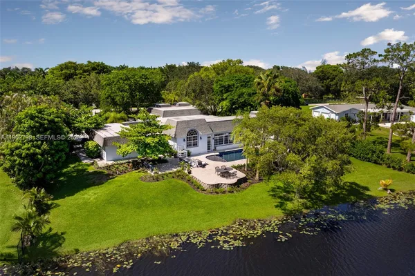an aerial view of a house with swimming pool a patio and garden