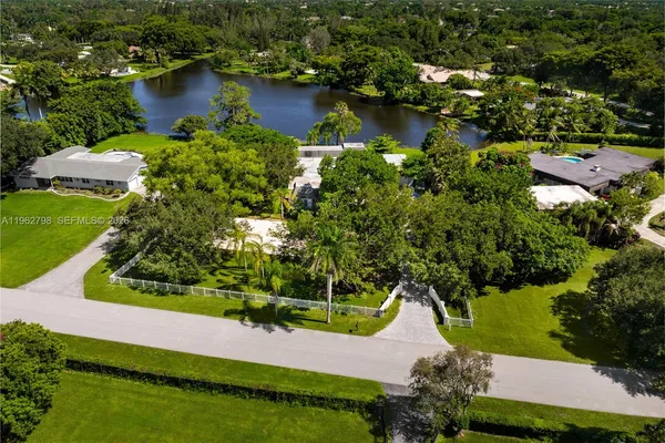 an aerial view of residential houses with outdoor space and lake view