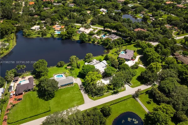 an aerial view of a house with a yard outdoor seating and swimming pool