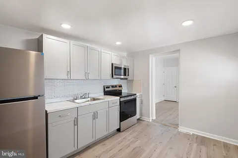 a kitchen with a sink a refrigerator and cabinets
