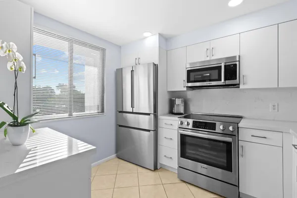a kitchen with cabinets stainless steel appliances and a counter space