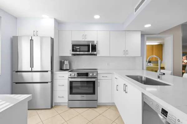 a kitchen with stainless steel appliances granite countertop a stove microwave and sink