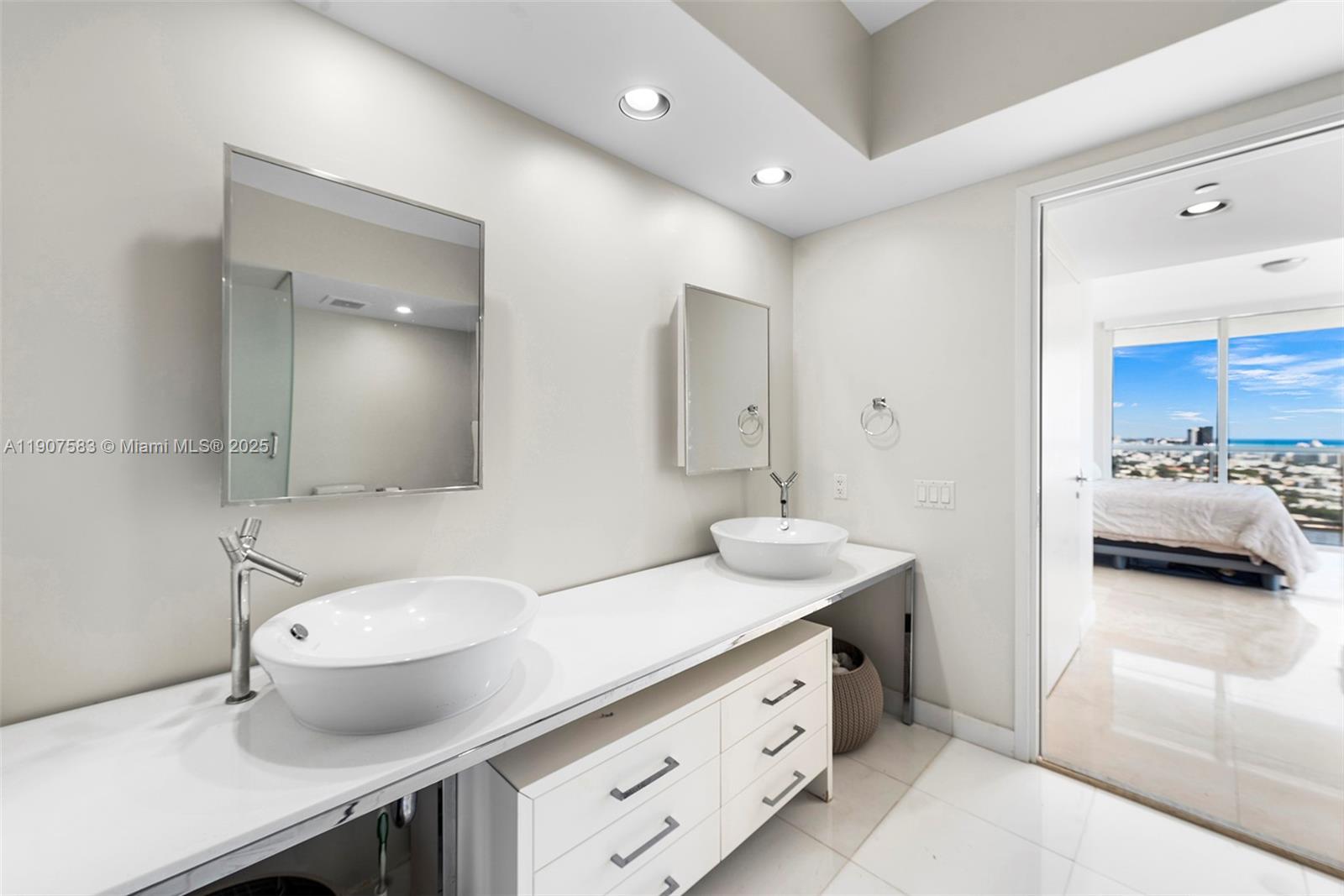 450 Alton Road, Unit 3010 Miami Beach, FL 33139 - Photo 23 of 62 a en suite bathroom with a granite countertop sink and a mirror