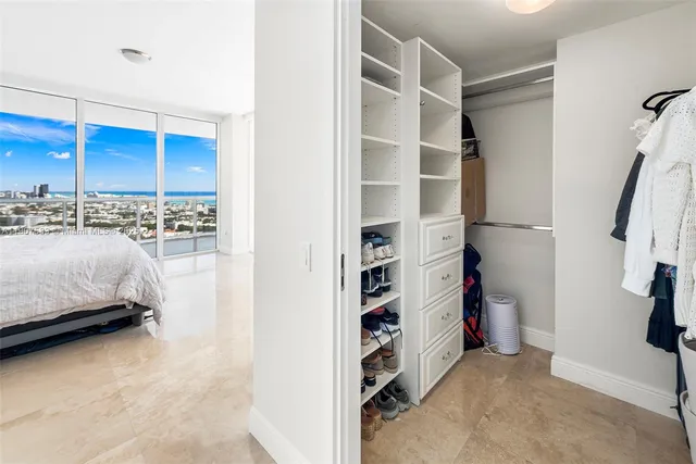 a bedroom with a bed and a large window