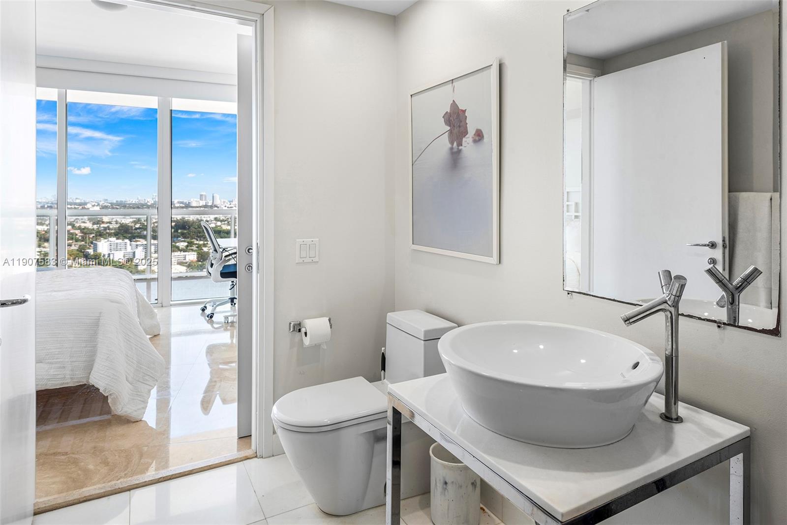 450 Alton Road, Unit 3010 Miami Beach, FL 33139 - Photo 37 of 62 a bathroom with a toilet a sink and a mirror