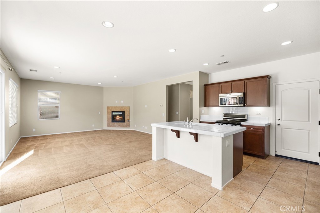 12047 Dewar Drive Riverside, CA 92505 - Photo 17 of 40 a kitchen with stainless steel appliances granite countertop a stove top oven a sink and dishwasher
