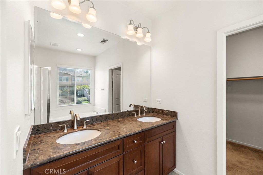 12047 Dewar Drive Riverside, CA 92505 - Photo 22 of 40 a bathroom with a granite countertop double vanity and a mirror