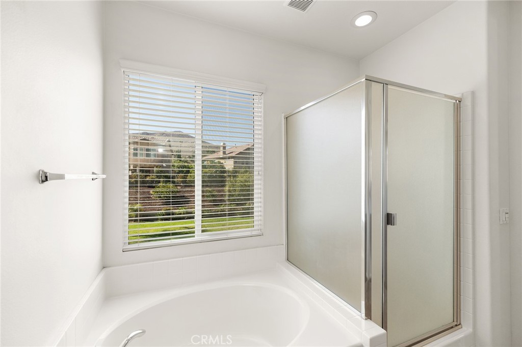 12047 Dewar Drive Riverside, CA 92505 - Photo 23 of 40 a bathroom with a bathtub and a shower
