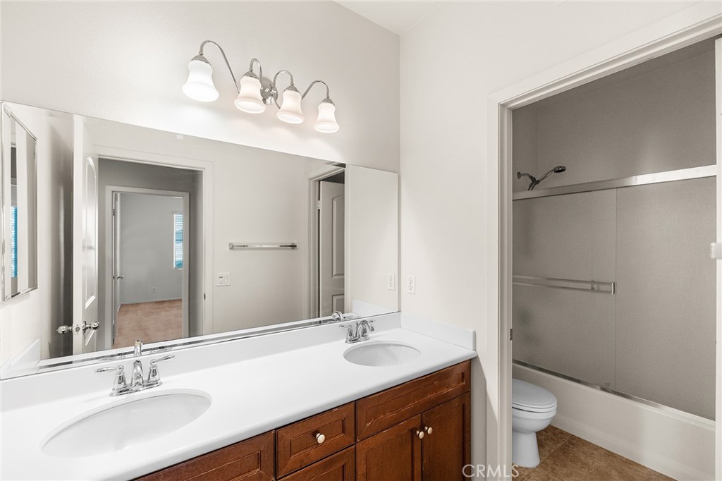 12047 Dewar Drive Riverside, CA 92505 - Photo 26 of 40 a bathroom with a double vanity sink toilet and a mirror
