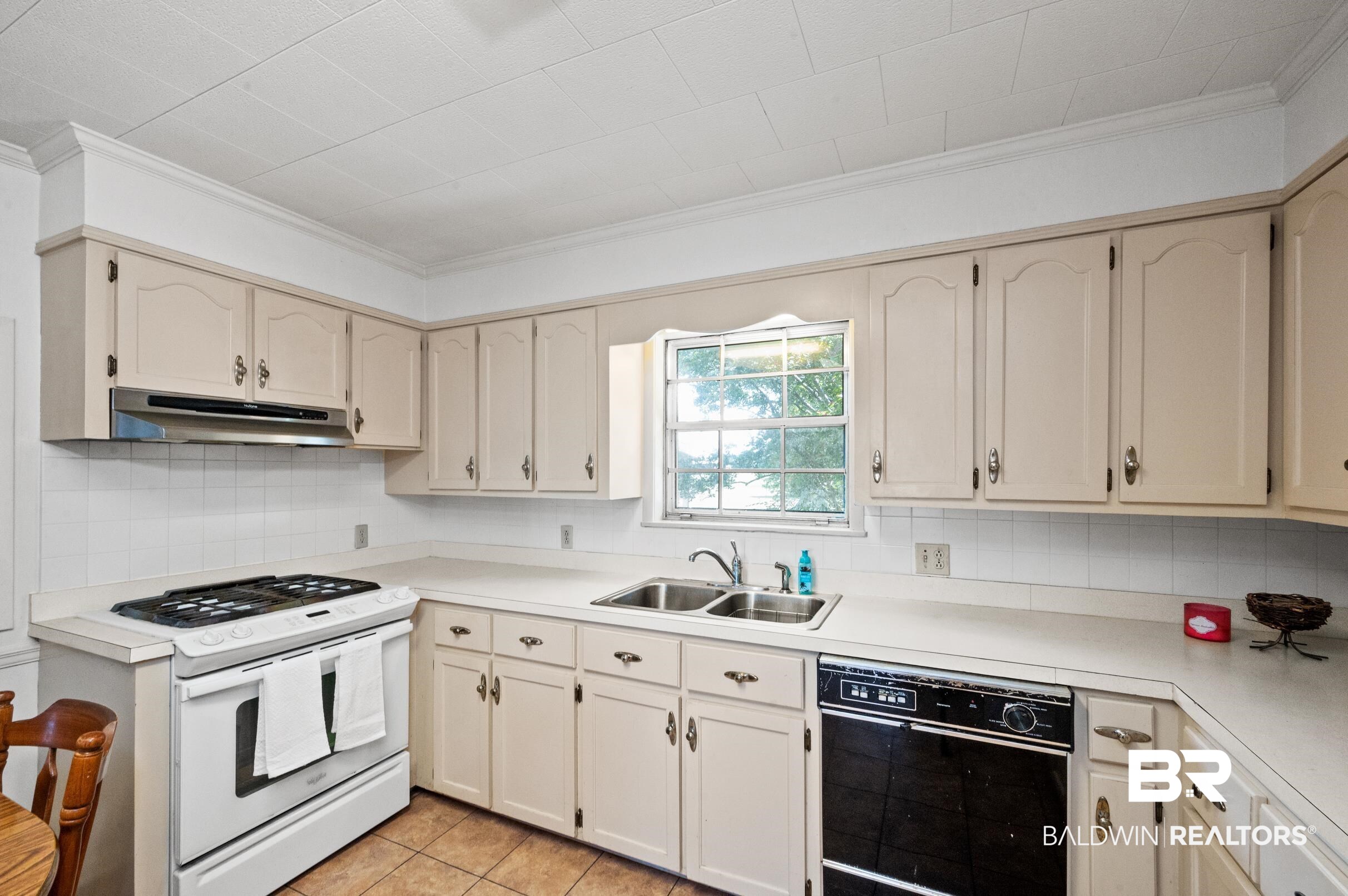 15600 Fackler Road Loxley, AL 36551 - Photo 10 of 51 Kitchen featuring black dishwasher, sink, decorative backsplash, light tile patterned floors, and white range with gas cooktop