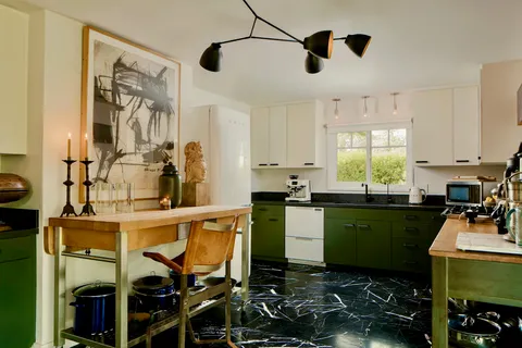 a dining room with wooden floor a chandelier a wooden table and chairs