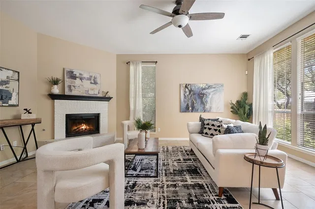 a living room with furniture a fireplace and a large window