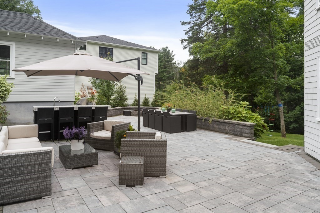 60 Rice Road Wayland, MA 01778 - Photo 17 of 26 a view of a patio with couches table and chairs under an umbrella