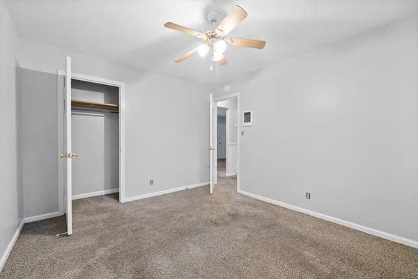 a view of an empty room with a ceiling fan