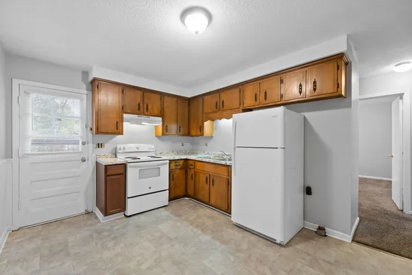 a kitchen with granite countertop cabinets and white appliances