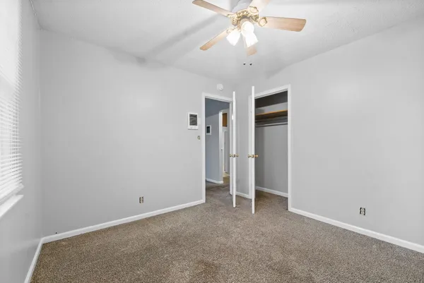 an empty room with a empty space and a ceiling fan