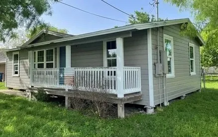 a view of a house with a yard and wooden fence