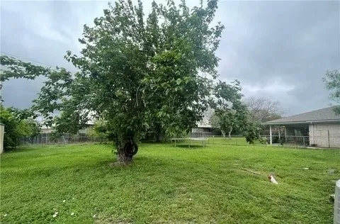 a view of a house with a big yard and large trees
