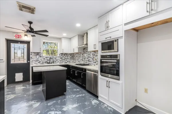 a kitchen with stainless steel appliances a sink stove and cabinets
