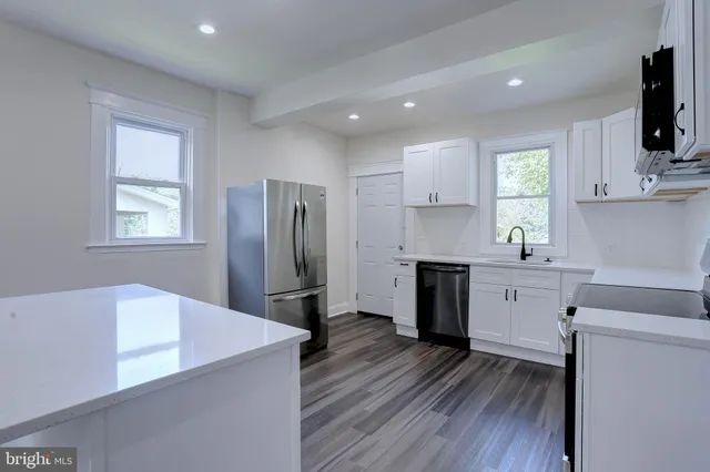 a kitchen with cabinets appliances a sink and a window