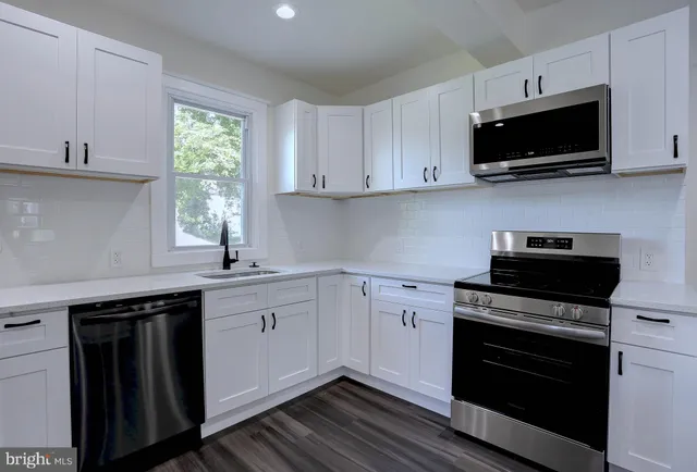 a bathroom with a granite countertop sink a mirror and wooden floor